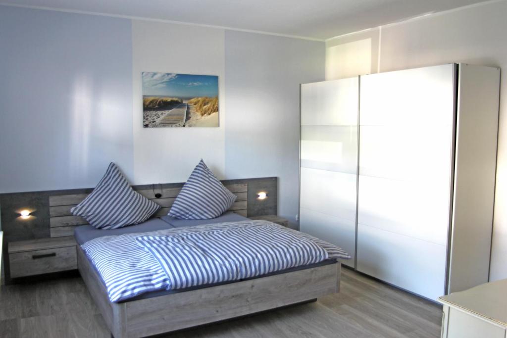 - une chambre avec un lit doté d'oreillers à rayures bleus et blancs dans l'établissement Ferienwohungen Arnold Boppard, à Boppard