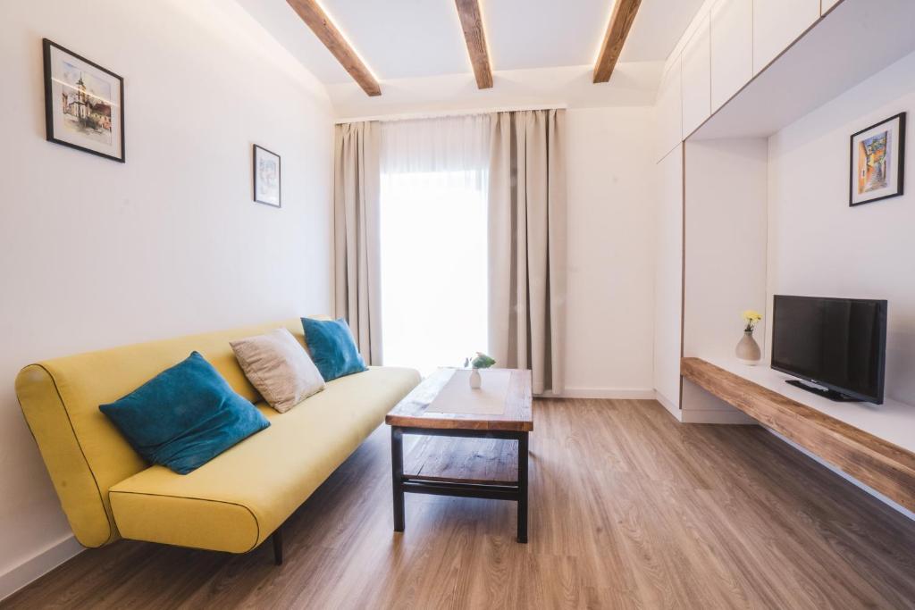 a living room with a yellow couch and a tv at Mathias Rex in Szentendre