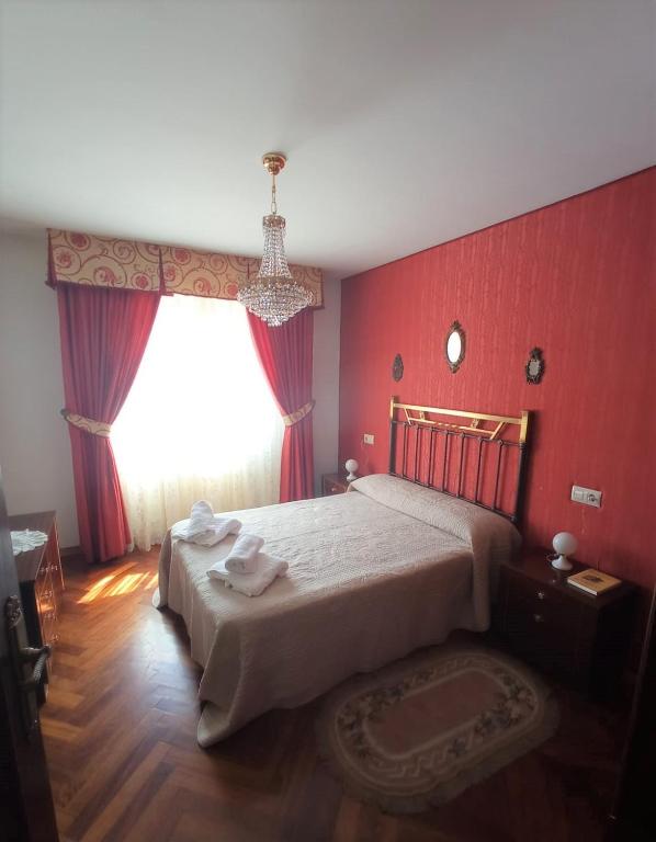 a bedroom with a large bed with red walls at Casa Navacastellanos in Casarejos