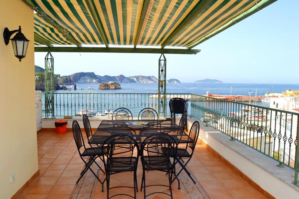 un tavolo e sedie su un balcone con vista sull'oceano di Maridea - Pesce Azzurro a Ponza