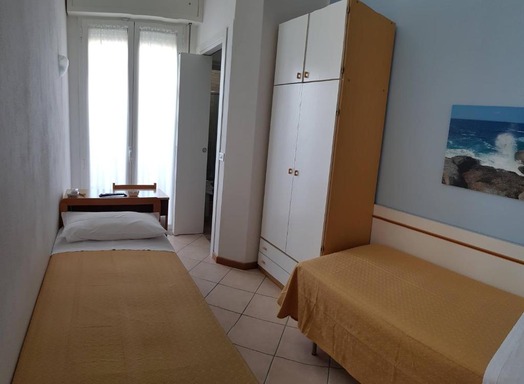 A bed or beds in a room at Albergo Roma Spiaggia
