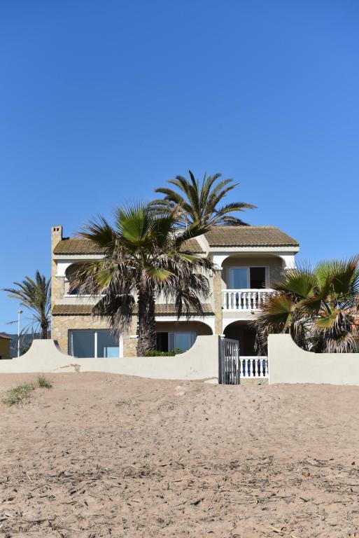 una casa sulla spiaggia con palme di Beach House Villa Roca a Cullera