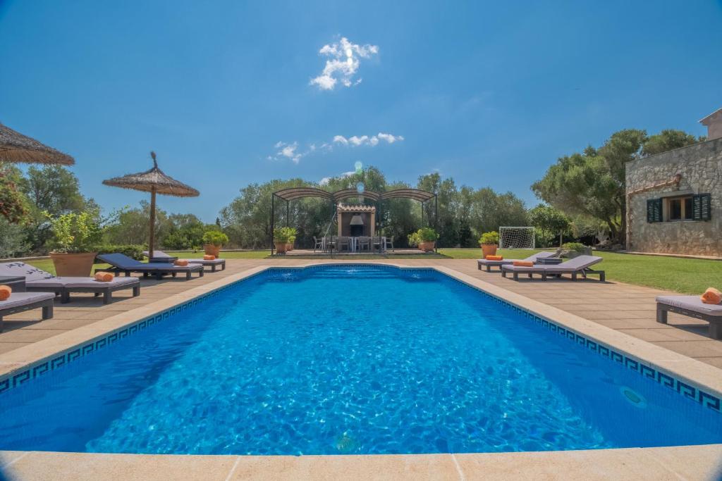 a swimming pool with lounge chairs and a house at G324 Vela 1 by Mallorca Villa Selection in Muro
