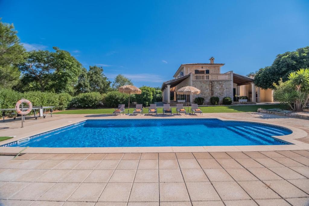 - une piscine avec des chaises et des parasols en face d'une maison dans l'établissement Finca VELA 2, à Muro