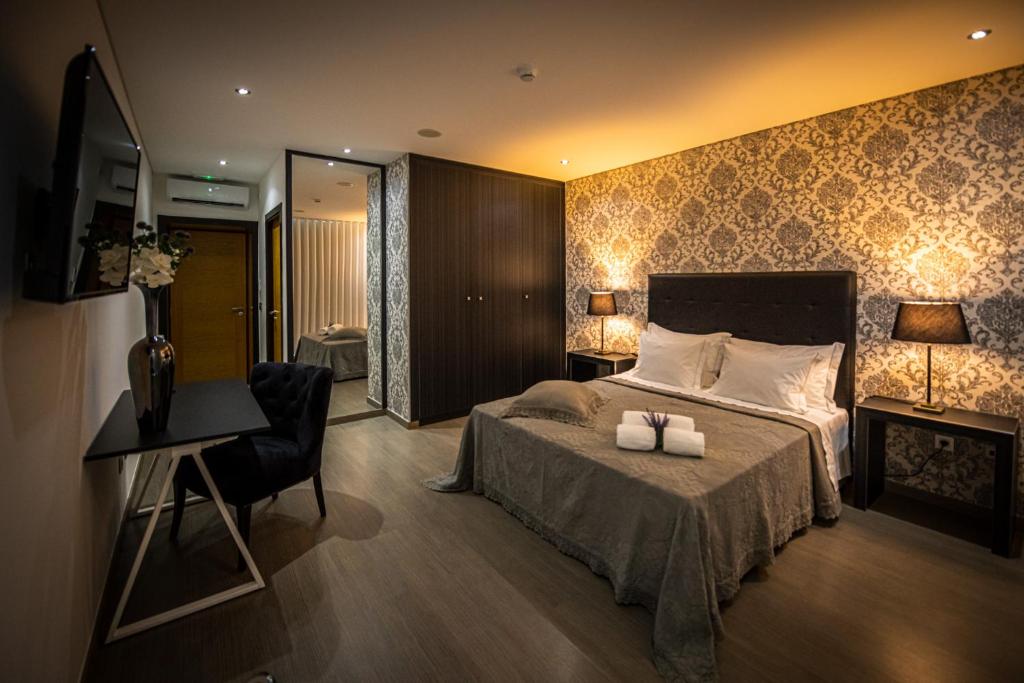 um quarto com uma cama, uma escrivaninha e uma cadeira em Quinta das Oliveiras Turismo Rural no Fundo