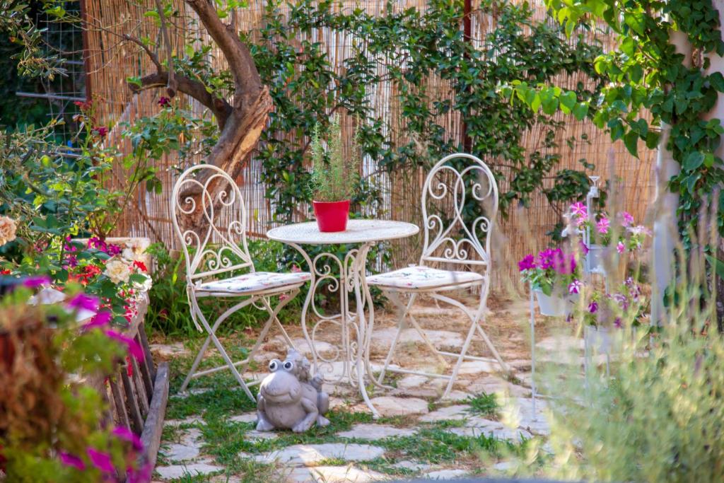 Spartýlas的住宿－Lorantina House_ Holidays in Corfu，花园内摆放着两把椅子和一张桌子