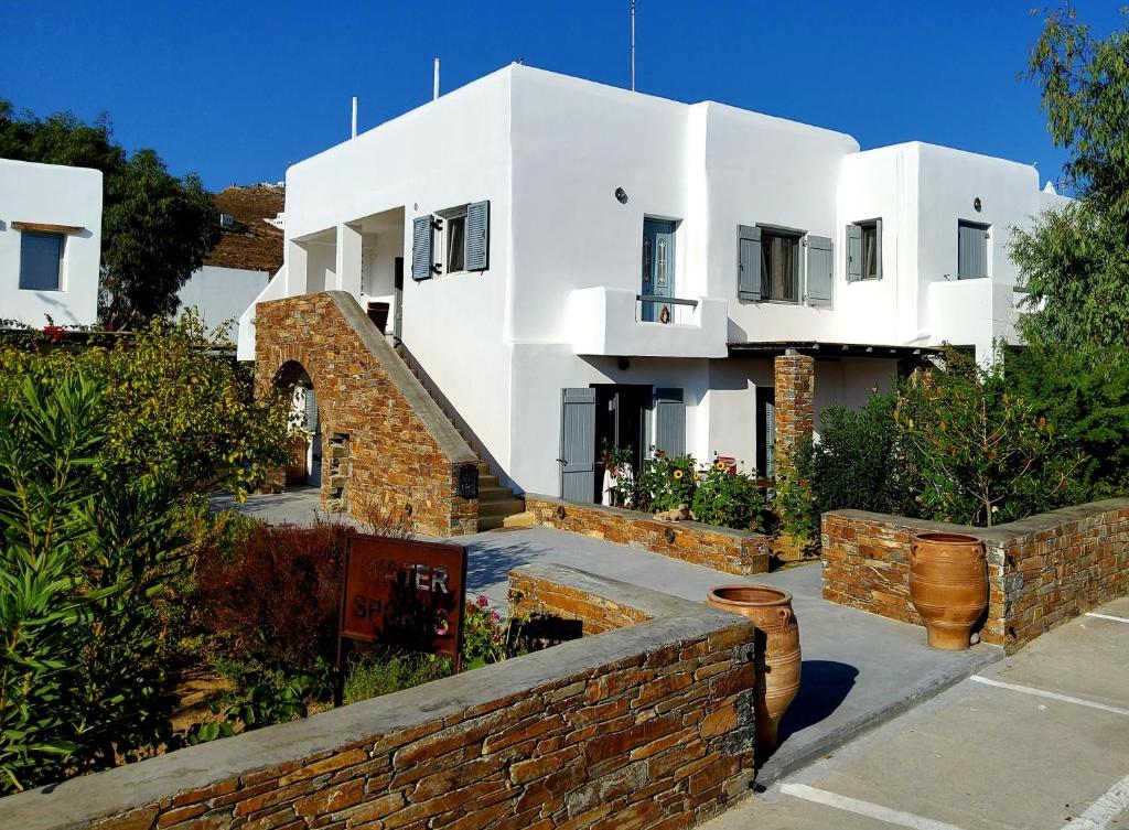 a large white house with a brick wall at Nefeli in Livadion