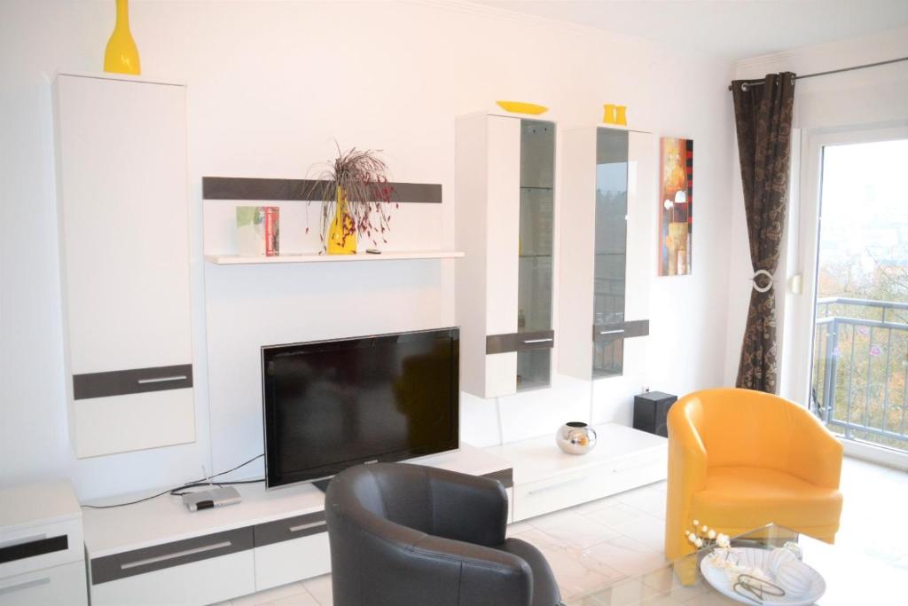 uma sala de estar com uma televisão e uma cadeira amarela em Herzog-Reichard em Simmern