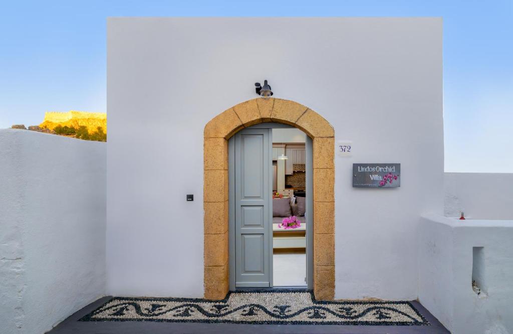 uma entrada para um edifício branco com uma arcada em Lindos orchid villa em Lindos
