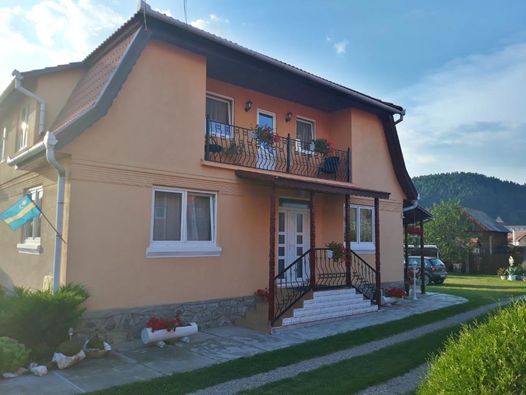 a house with a porch and a balcony at Gabriella vendégház in Lăzarea