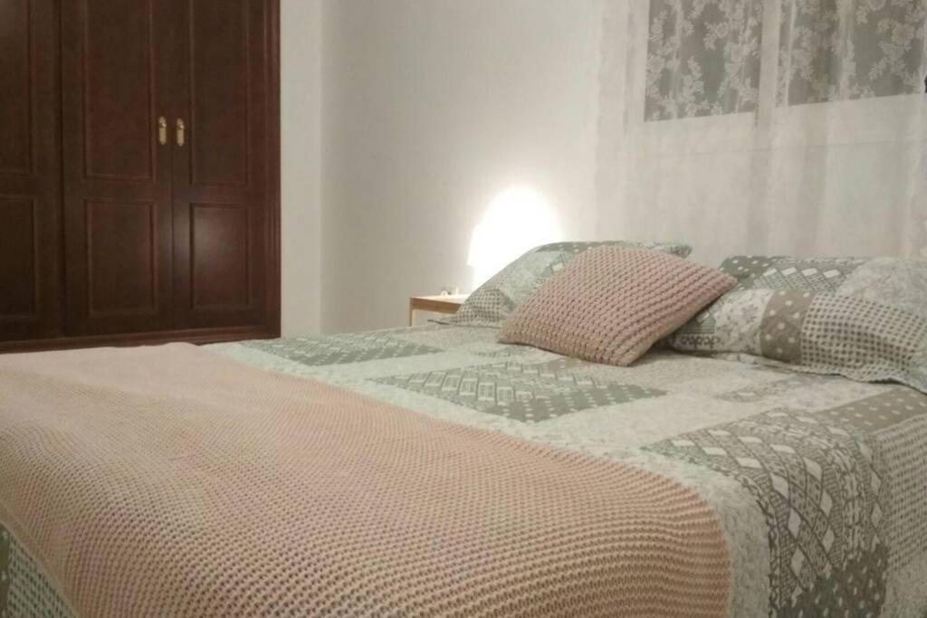 uma cama com duas almofadas num quarto em Beautiful House Sierrecilla em Humilladero