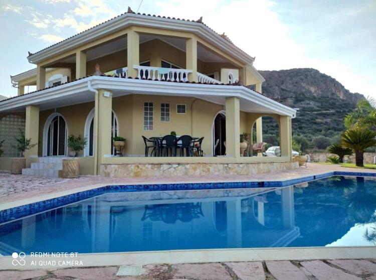 uma casa com uma piscina em frente em Achilles Apartment em Nafplio