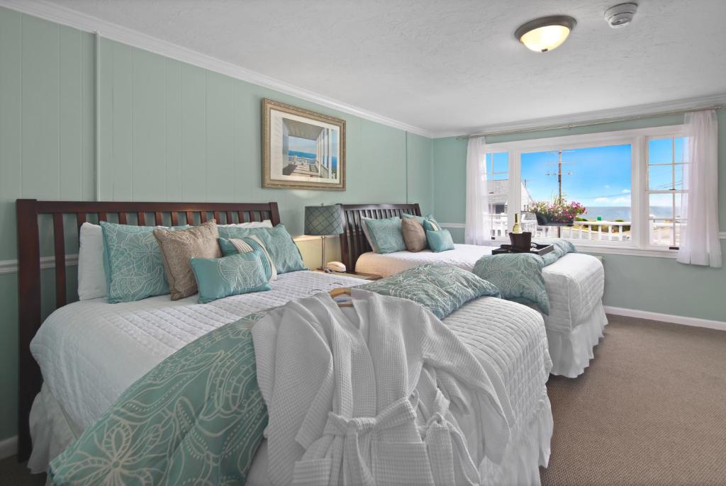 a bedroom with two beds and a view of the ocean at Nantasket Beach Hotel in Hull
