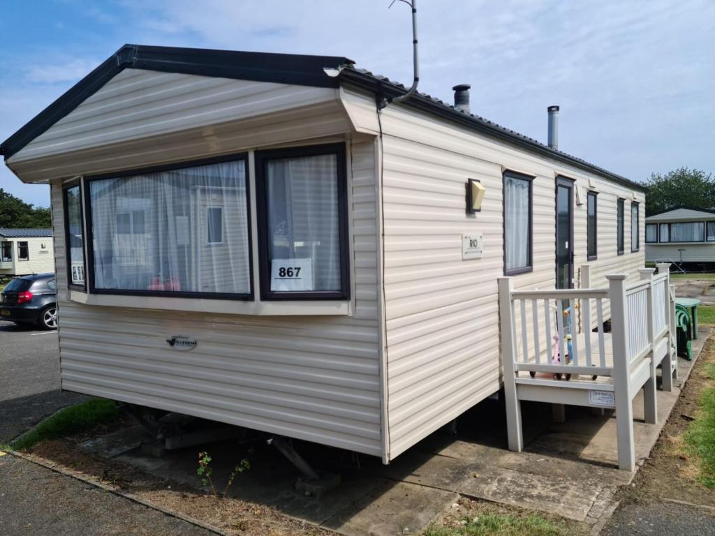 a white tiny house with a porch and a balcony at Skegness Holidays at Haven in Skegness