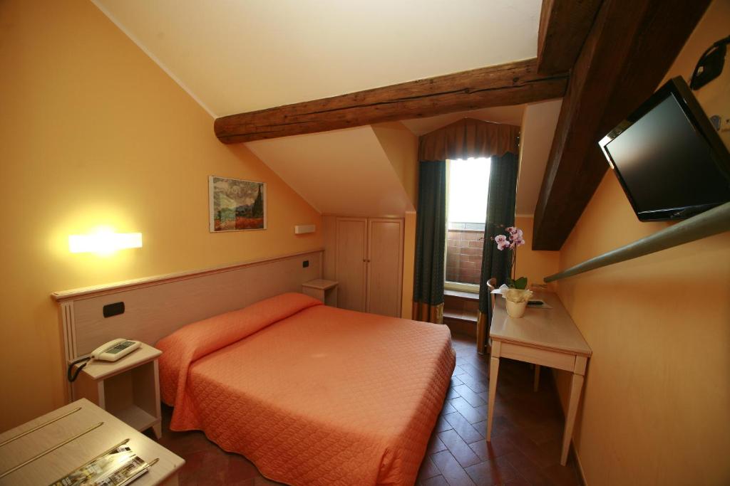 pokój hotelowy z łóżkiem i telewizorem z płaskim ekranem w obiekcie Hotel Excelsior Splendide w mieście Bellagio