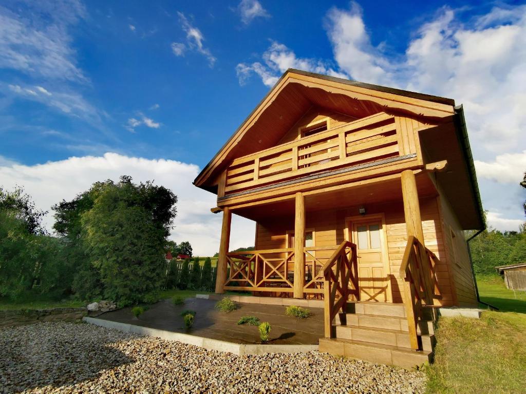 a log cabin with a porch and a deck at Domki u Basi in Kluszkowce