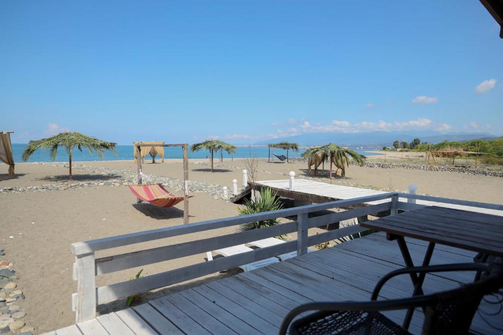 a wooden deck with a table on the beach at Aqua Resort Hotel in Sukhum