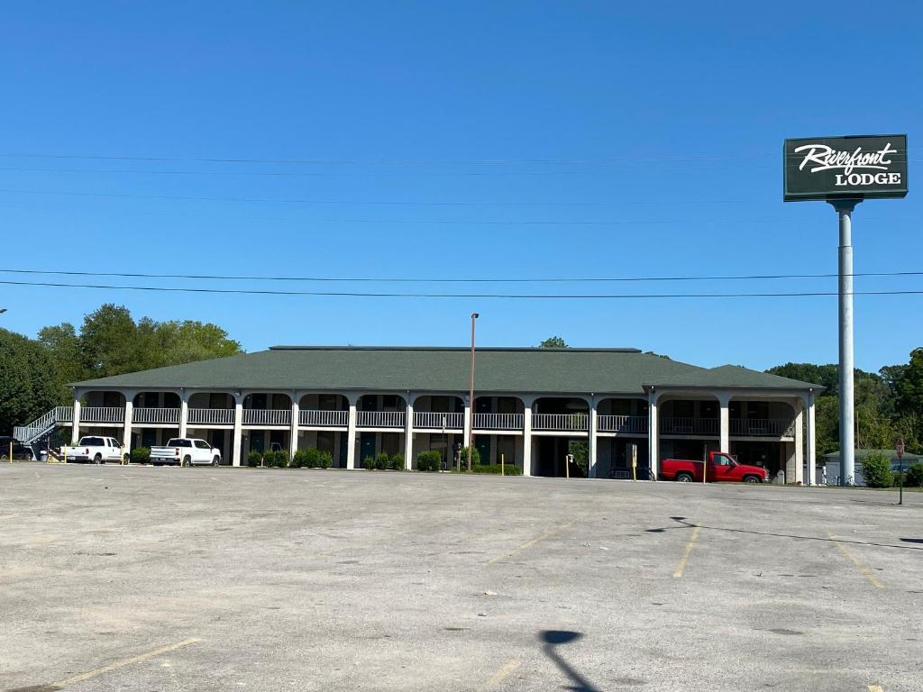a parking lot in front of a large building at Riverfront Lodge in Burkesville