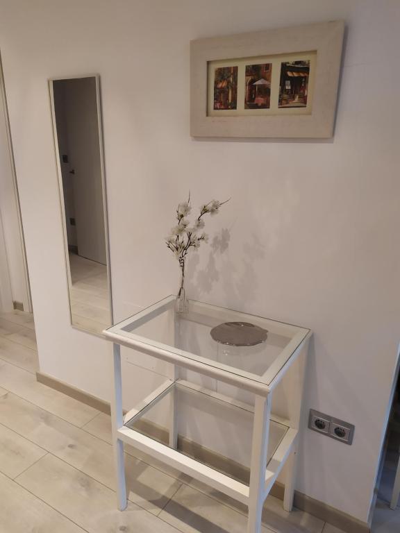 a white table with a vase with a plant on it at EL RINCON DE LUZ 2 in Padrón