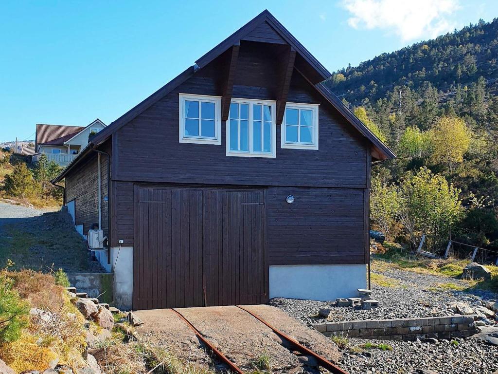 una casa marrone con una porta e due finestre di Holiday home Svelgen a Svelgen