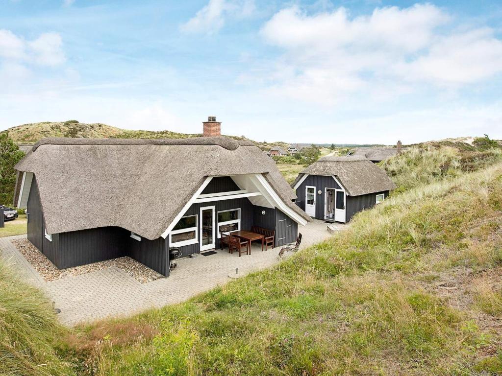een huis met een rieten dak op een heuvel bij 8 person holiday home in Henne in Henne Strand
