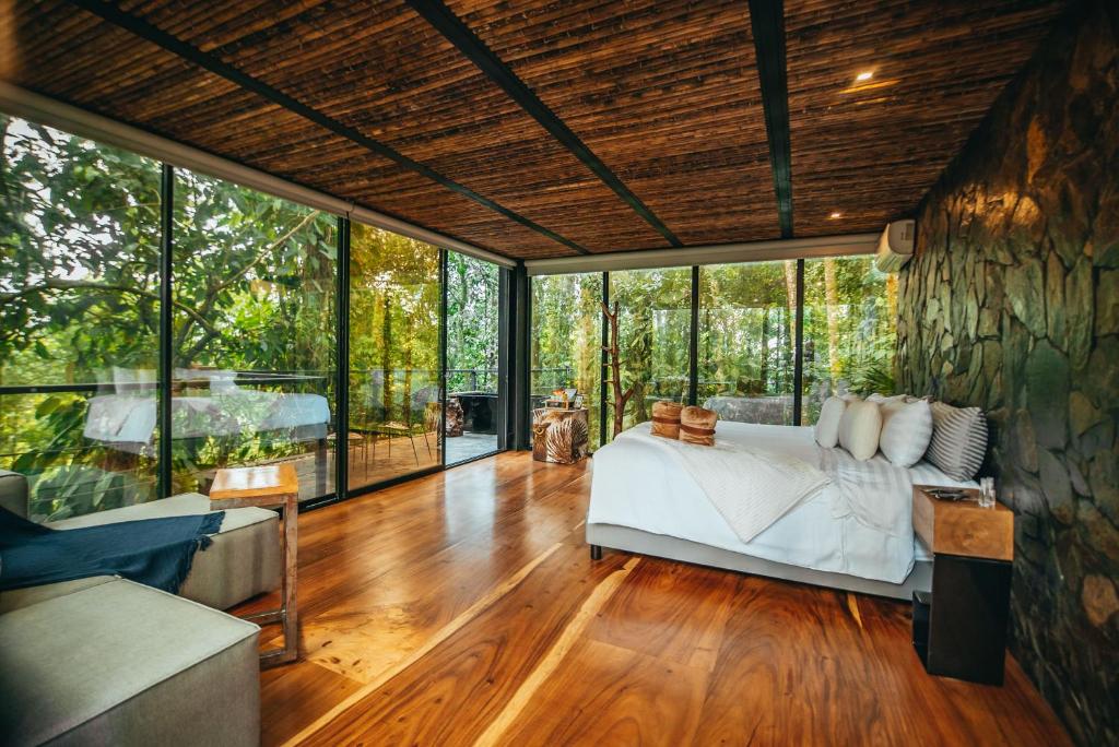 a bedroom with a bed in a room with glass walls at Bio Habitat Hotel in Armenia