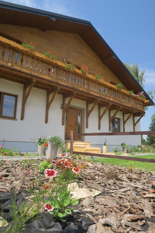 ein Haus mit einem Balkon und Blumen davor in der Unterkunft Base Camp Carpathia in Wrocanka