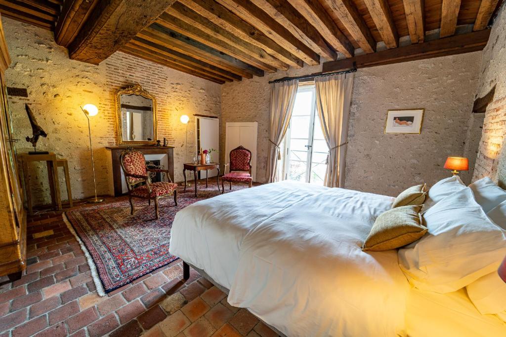 een slaapkamer met een groot bed in een kamer bij l'eau vive in Mer