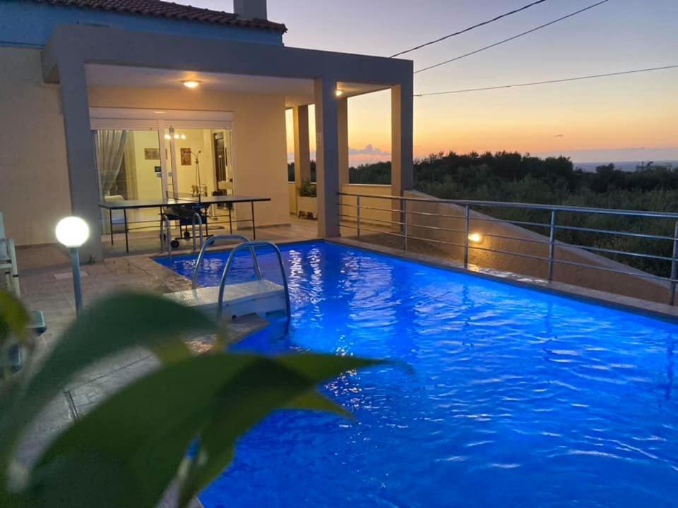una gran piscina azul frente a una casa en Villa Zafira, en Prínos