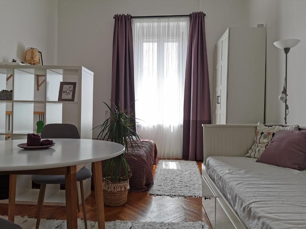 ein Wohnzimmer mit einem Sofa und einem Tisch in der Unterkunft CityCenter Apartment TTO in Győr