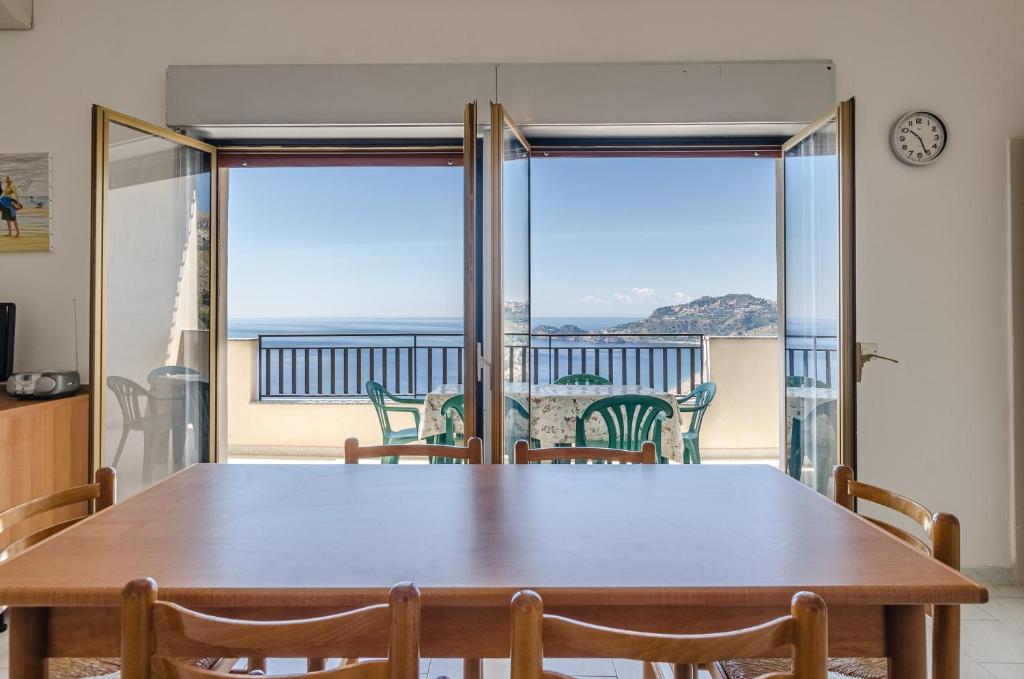 a dining room table with a view of the ocean at CASA VACANZE ANDREANA in Letojanni