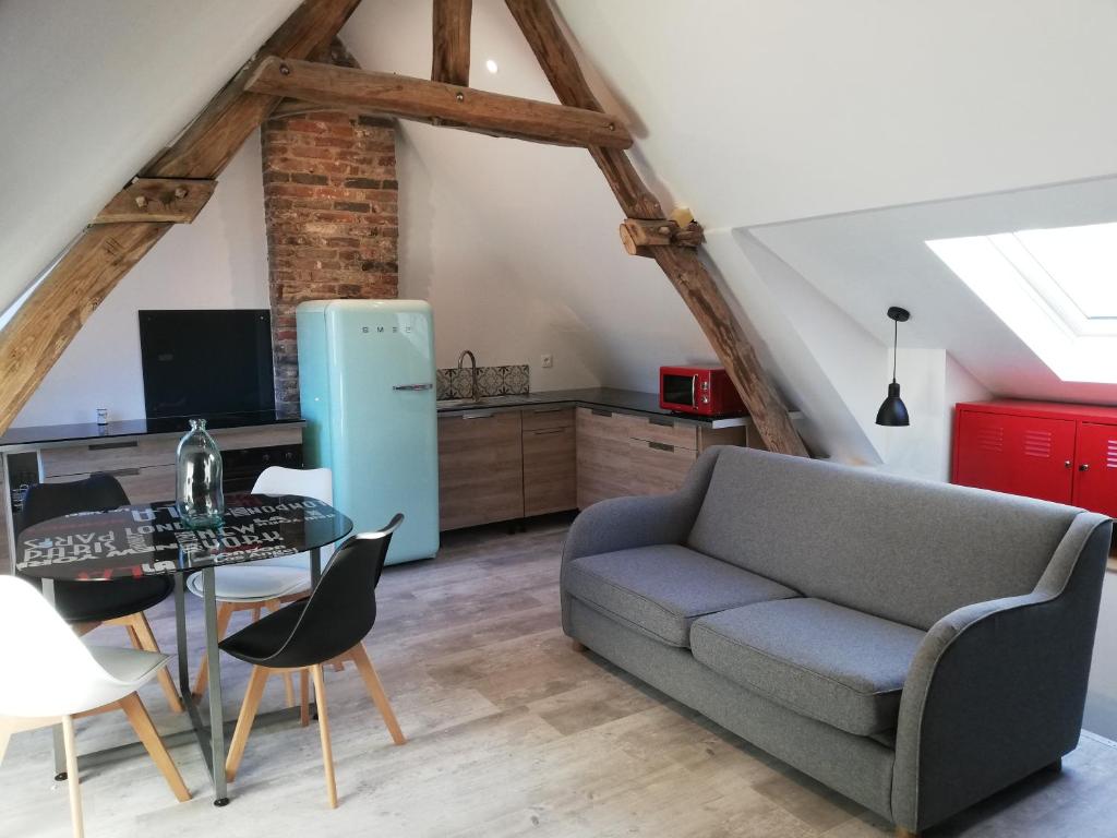 uma sala de estar com um sofá e uma mesa em Au cochon qui rit em Flines-lès-Mortagne