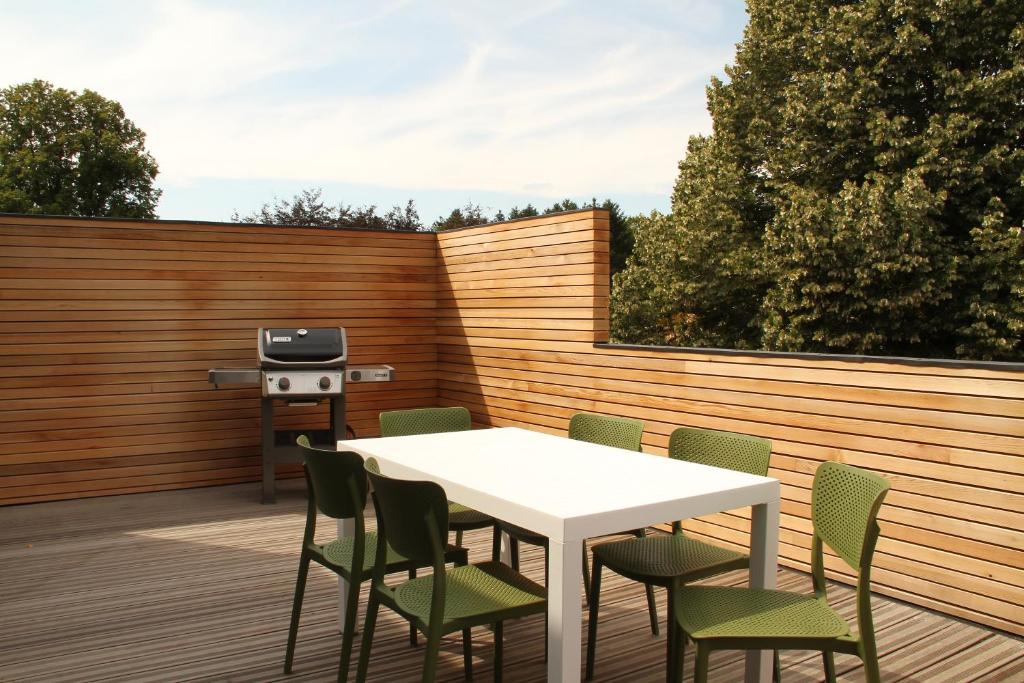 une terrasse avec une table blanche, des chaises et un grill dans l'établissement Chez Pilar, à Modave