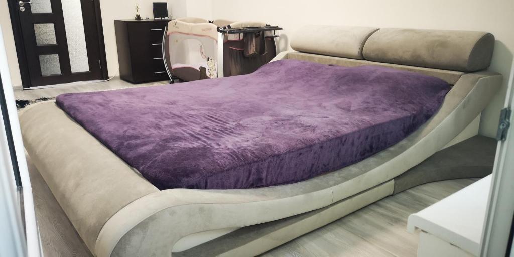 a bed with a purple blanket on top of it at Apartment in Varna City