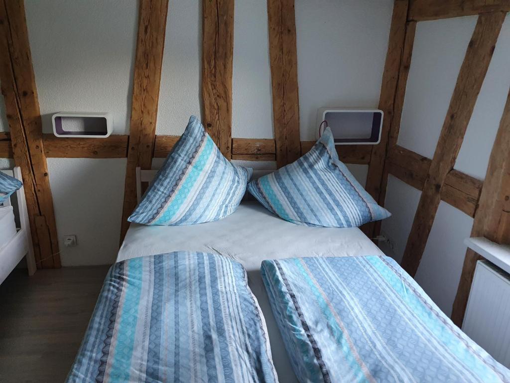 ein Bett mit zwei blauen Kissen in einem Zimmer in der Unterkunft Apartment Happy Memories in Titisee-Neustadt