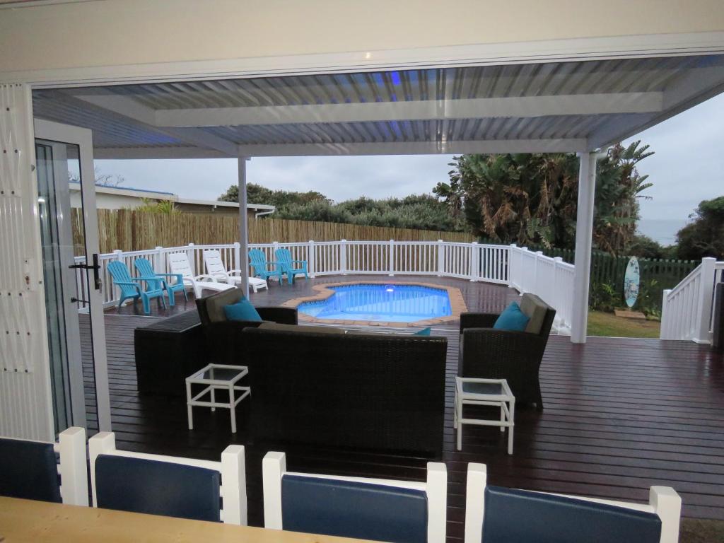 eine Terrasse mit Gartenmöbeln und einem Pool in der Unterkunft Seagulls Beach House in Port Shepstone