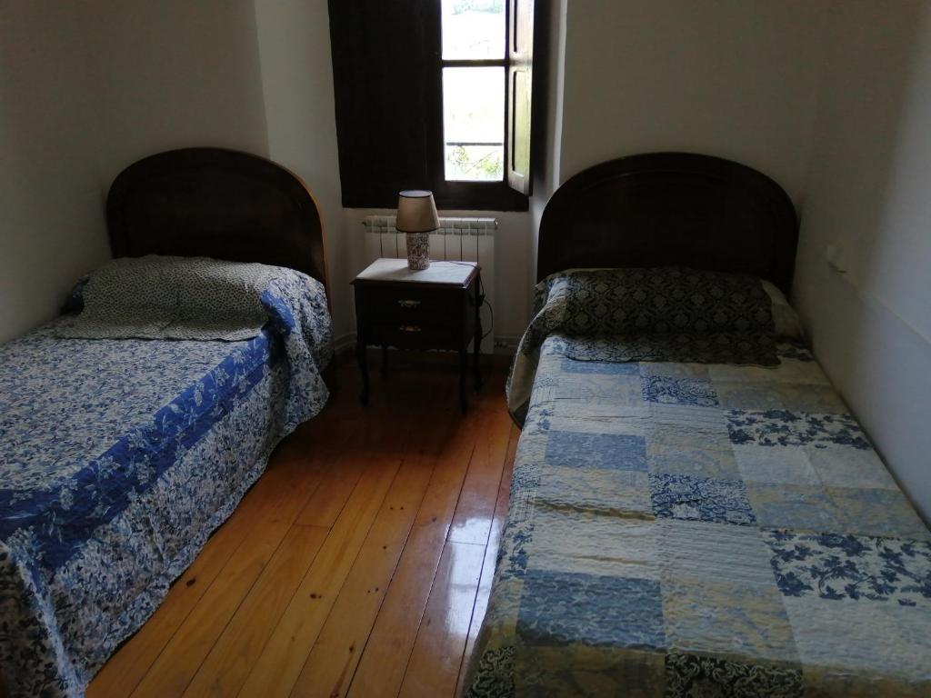 a bedroom with two beds and a table with a window at Labaiengo Ostatua in Beinza-Labayen