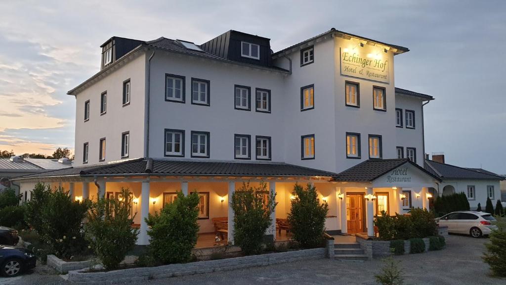 a large white building with lights on it at Hotel Echinger Hof in Eching