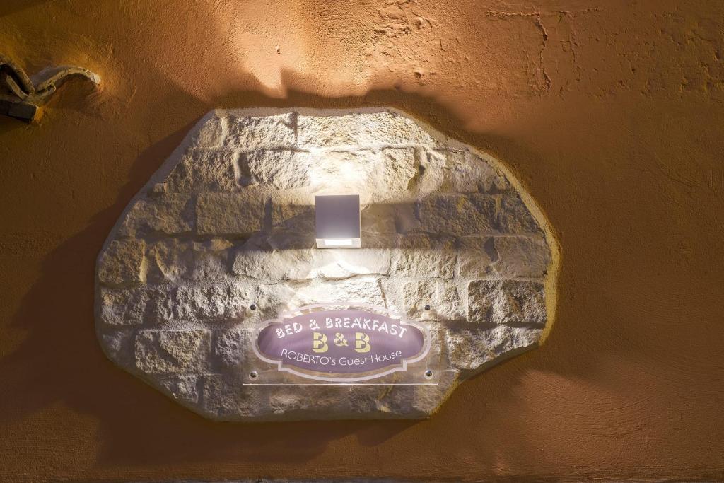 ceglana ściana z napisem w obiekcie ROBERTO's Guest House w mieście Andria
