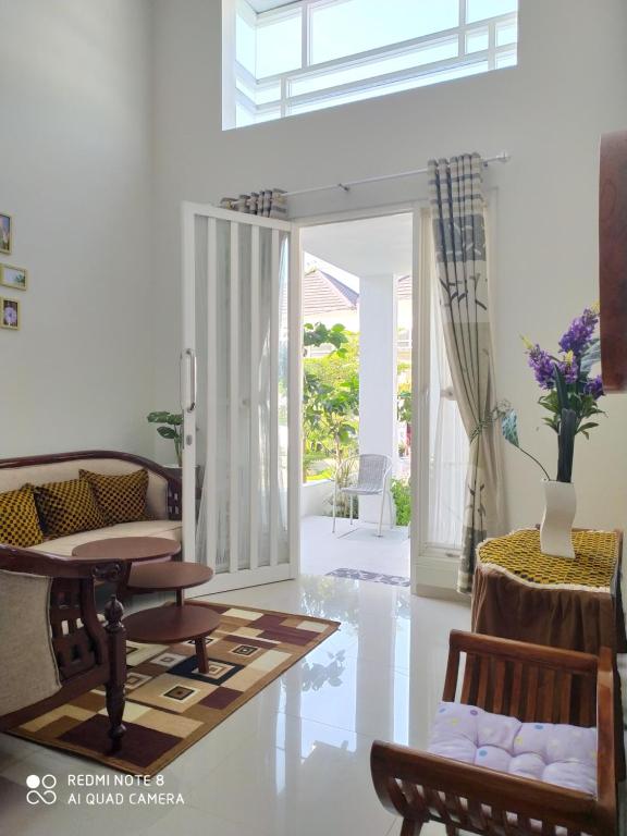 a living room with a table and chairs and a table at Alysahouse - 2 Bedrooms, Dekat JTP3 in Batu