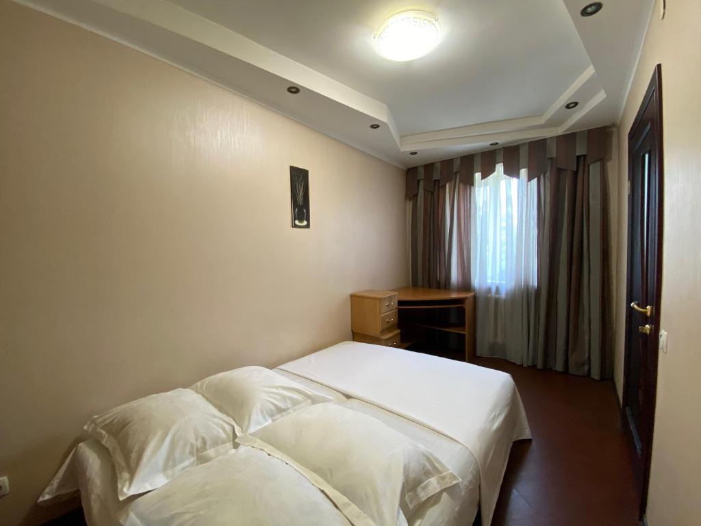 ein Schlafzimmer mit einem weißen Bett und einem Fenster in der Unterkunft Comfy Apartment Most City Area in Dnipro