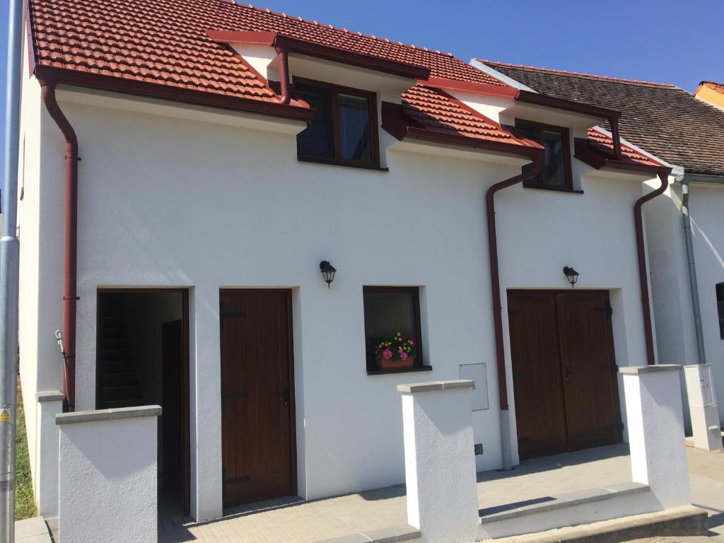 a white house with brown doors and a red roof at Ubytování nad sklípkem v Šatově in Šatov