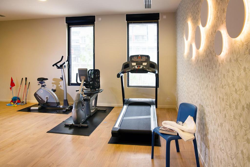 a gym with treadmill and exercise equipment in a room at Domitys - Galilée in Cergy