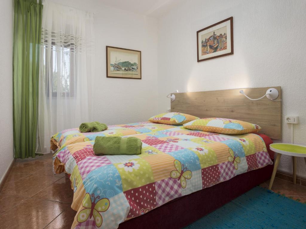 ein Schlafzimmer mit einem Bett mit einer bunten Bettdecke in der Unterkunft Karmelo Appartment Davorka in Rovinj