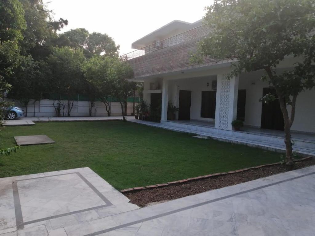 a yard in front of a house with a lawn at Capri Residency in Islamabad