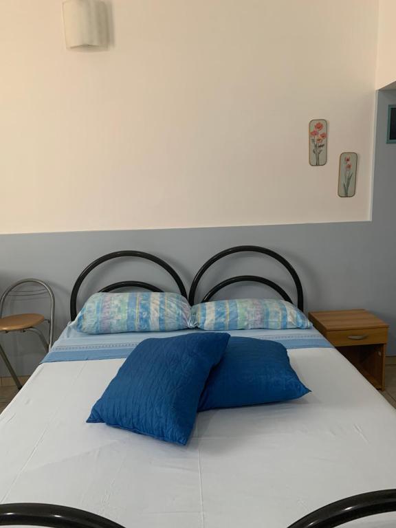 a bed with two blue pillows on top of it at Loft Rapisardi in Catania