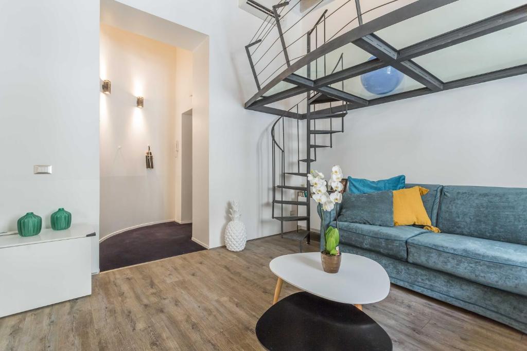 ein Wohnzimmer mit einem blauen Sofa und einem Tisch in der Unterkunft Casa Manara in Trastevere in Rom
