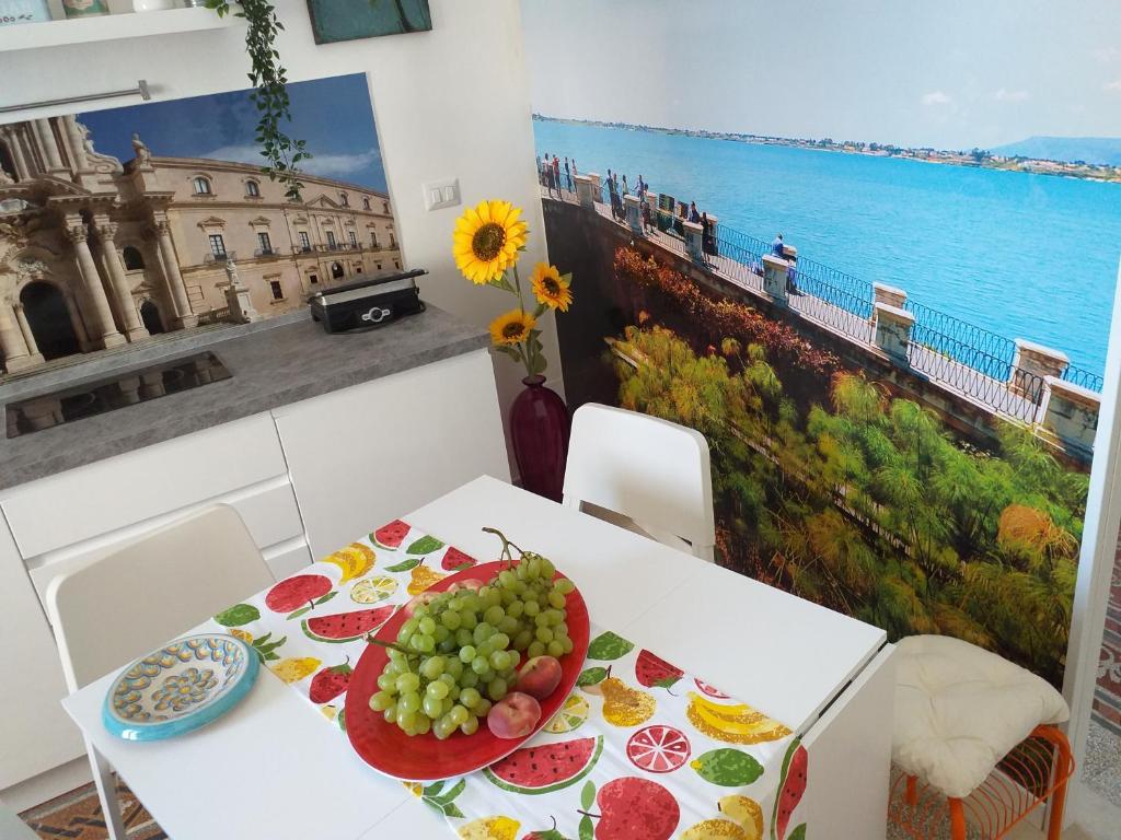 a white table with a plate of fruit on it at Casa Dreaming Ortigia in Siracusa