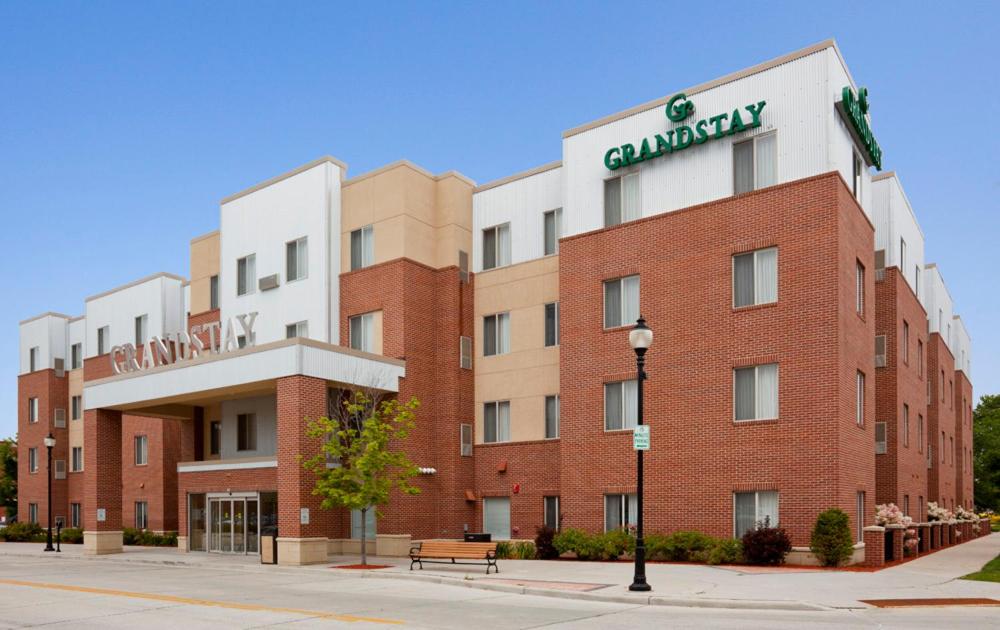 a large red brick building with a campus sign on it at GrandStay Hotel & Suites Downtown Sheboygan in Sheboygan