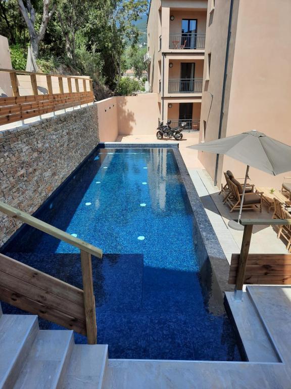 a swimming pool with blue water in a building at Hôtel Casa Mea in Bastia